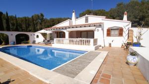Villa con piscina frente a una casa en Marmirada en Sant Lluis