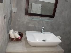 W łazience znajduje się biała umywalka i lustro. w obiekcie Sigiri Veenus Paradise w mieście Sigirija