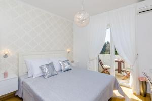 Habitación blanca con cama y ventana en Magellan Deluxe Two, en Dubrovnik