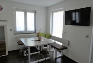 - une salle à manger blanche avec une table et des chaises blanches dans l'établissement Ferienwohnung Relax, à Rust