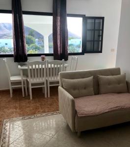 een woonkamer met een bank, een tafel en ramen bij Love Yaiza in Yaiza