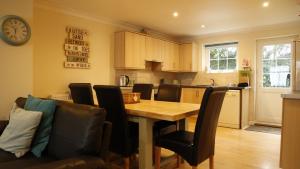 a kitchen and dining room with a wooden table and chairs at Seashells in Newquay