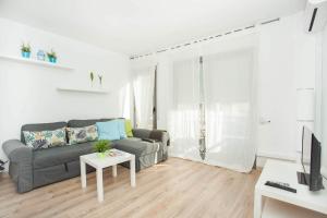 ein Wohnzimmer mit einem Sofa und einem Tisch in der Unterkunft Sitges Center & Beach Espalter in Sitges