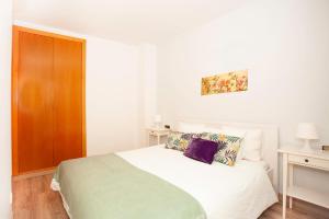 a bedroom with a white bed and a wooden cabinet at Sitges Center & Beach Espalter in Sitges +21 photos
