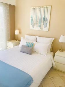 um quarto com uma cama branca e almofadas brancas em Cap View em Antibes