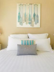a bed with white pillows and utensils hanging above it at Cap View in Antibes