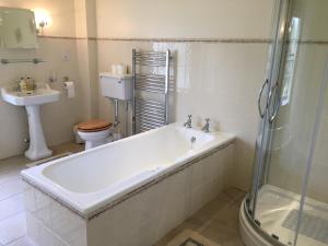 a bathroom with a tub and a toilet and a sink at Buckton Farmhouse in Belford +53 photos