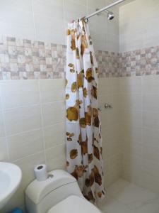 a bathroom with a shower curtain and a toilet at La Casa De Yoni in Puno