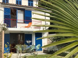 a house with blue walls and a palm tree at Modern & Comfy Sea View House NG in Portorož