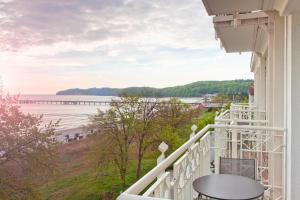 einen Balkon mit Blick auf den Strand und den Pier in der Unterkunft Hotel AM MEER & Spa in Binz
