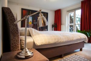 a bedroom with a bed with a lamp on a table at Suite 30 - kingsize groundfloor hotelapartment with parking in Groningen