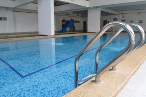 a swimming pool with blue water and silver railings at Amansari Residence Resort in Johor Bahru
