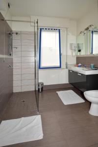 een badkamer met een douche, een toilet en een wastafel bij Albergo Cavallucci in Sermide