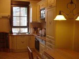 a kitchen with white cabinets and a sink and a window at Ferienwohnung Zossen in Zossen