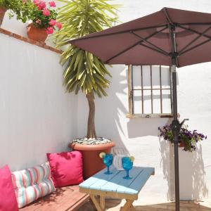 un patio con mesa y sombrilla en Casa Mosaico Granada en el V de Lecrin, en Nigüelas