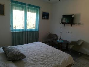a bedroom with a bed and a table and a television at Guesthouse Porec in Poreč