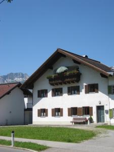 a white building with a bench in front of it at Ferienwohnung Kathrein in Reutte