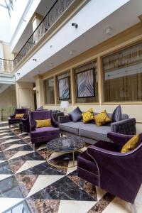 a living room with purple couches and tables at Royal BV in Ustʼ-Kamenogorsk