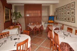een restaurant met tafels en stoelen met witte tafelkleden bij Albergo Cavallucci in Sermide