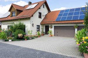 a house with solar panels on the roof at Ferienwohnung Sonja mit Westbalkon in Neualbenreuth