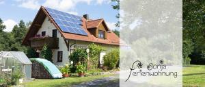 una casa con techo con paneles solares en Ferienwohnung Sonja mit Westbalkon, en Neualbenreuth