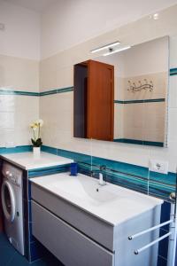 a bathroom with a sink and a washing machine at La Perla Bianca in Sorrento