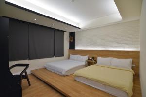 1 dormitorio con 2 camas y ventana grande en 水菓糖民宿 en Taitung
