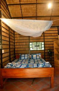 a bed in a room with a mosquito net at Mekong Farmstay CanTho - C.R Floating Market in Can Tho