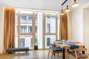 a dining room with a table and a large window at Downtown apartment in Vilnius str. in Vilnius