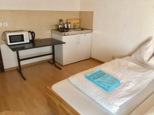 a small room with a bed and a table with a microwave at Linda Apartment 33 in Interlaken
