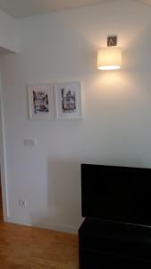 uma sala de estar com televisão e uma luz na parede em Miradouro de Santa Luzia em Lisboa