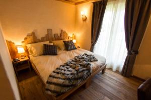 ein Schlafzimmer mit einem Bett mit einer Decke darauf in der Unterkunft Hotel Les Montagnards in Morgex
