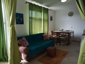 a living room with a green couch and a table at David in 4 in Primošten +15 photos