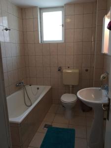 a bathroom with a tub and a toilet and a sink at David in 4 in Primošten