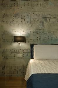 a bedroom with a wall covered in sheet music at Antico Sipario Boutique Hotel, BW Signature Collection in Paciano