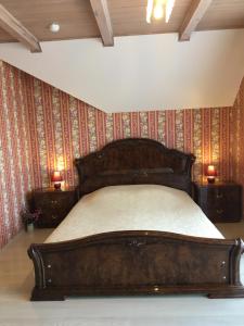 a bedroom with a wooden bed in a room with wallpaper at Kurenas in Juodkrantė
