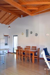 uma cozinha e sala de jantar com uma mesa de madeira e cadeiras em Casa do Outeiro em Penacova