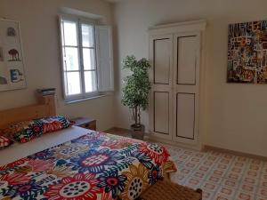 een slaapkamer met een bed met een kleurrijke sprei en een raam bij Francesca House in Pisa
