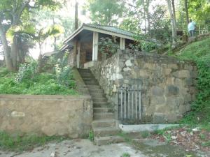 a small house on a hill with a stone wall and stairs at Green Valley Holiday Resort in Haputale