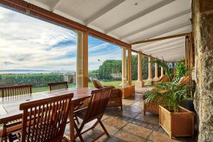 Un patio al aire libre con una mesa y sillas de madera. en Greystones Beach House, en Langebaan 15 fotos más