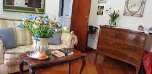 una sala de estar con un jarrón de flores sobre una mesa en Palazzo Morosini Brandolin Dimora Romantica en Venecia