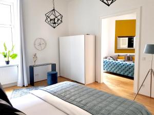 ein Wohnzimmer mit einem weißen Kühlschrank und einem Sofa in der Unterkunft Belle Epoque in Wien
