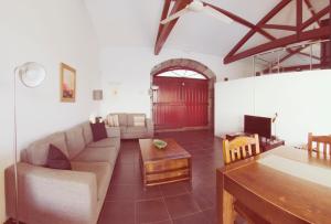 een woonkamer met een bank en een tafel bij QVA - Quinta Velha das Amoreiras in Vila Franca do Campo
