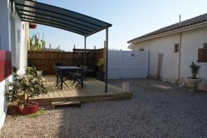 - une terrasse avec une table et un auvent à côté d'une maison dans l'établissement MARIBEN, à Pujols Gironde