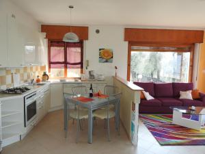 una cucina e un soggiorno con tavolo e divano viola di Casa Sant'Antonio a Malcesine