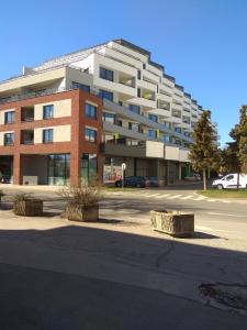 a large brick building in a parking lot at Košice Smart Apartmán in Košice