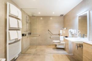 
a bathroom with a toilet, sink, and bathtub at Hotel Donny in De Panne
