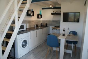 a kitchen with a washing machine and a table with chairs at MARIBEN in Pujols Gironde