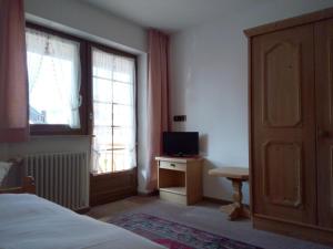 a bedroom with a bed and a television on a table at Gästehaus Rössle in Friedenweiler-Rotenbach