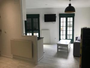a living room with a couch and a table and a tv at Loft Casco Viejo 3 in Ourense +8 photos